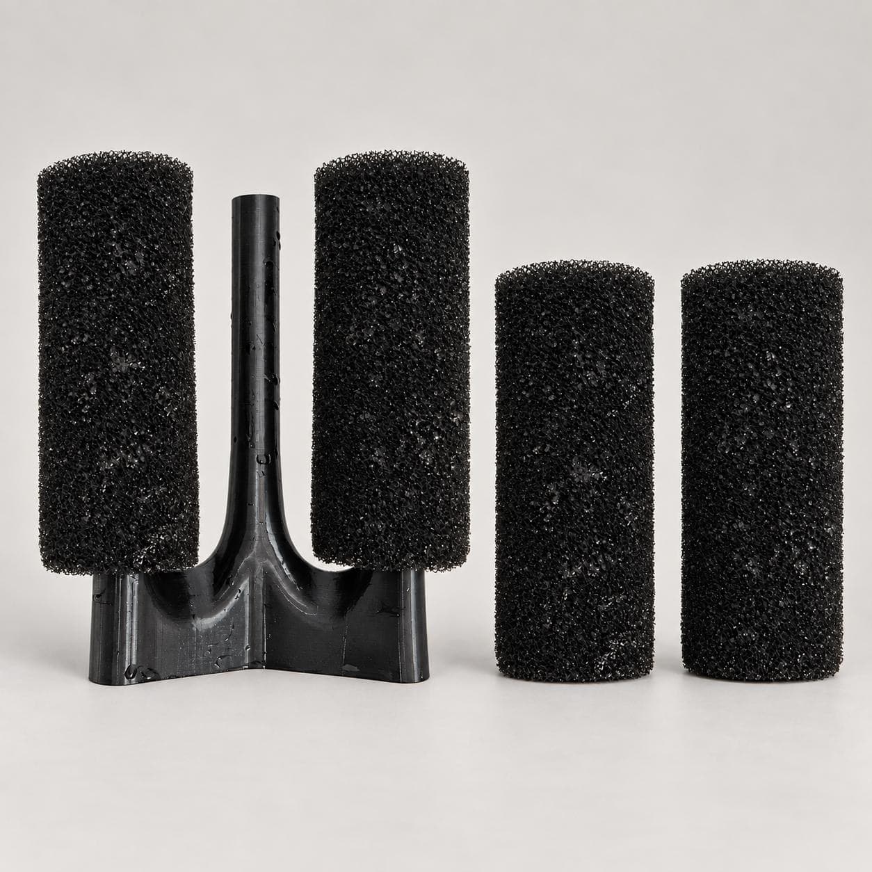 Adapter with two sponges fitted and two spare sponges beside it, the four-sponge package